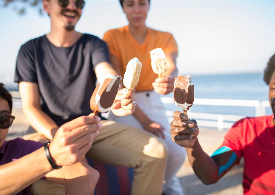A group of friends holding ice cream cones outdoors